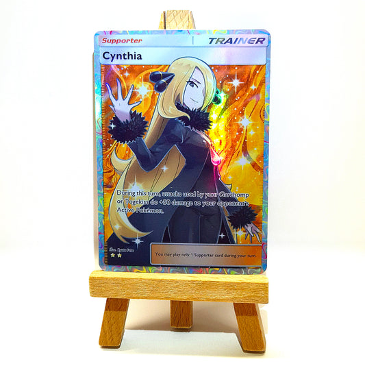 Cynthia Supporter-Karte im Holo-Design mit gold-orangenem Hintergrund. Custom Pokémon Trainer-Karte handgemacht, passend für Standard-Hüllen.
Cynthia supporter card with holo finish and golden background. Handmade custom Pokémon trainer card, fits standard sleeves.